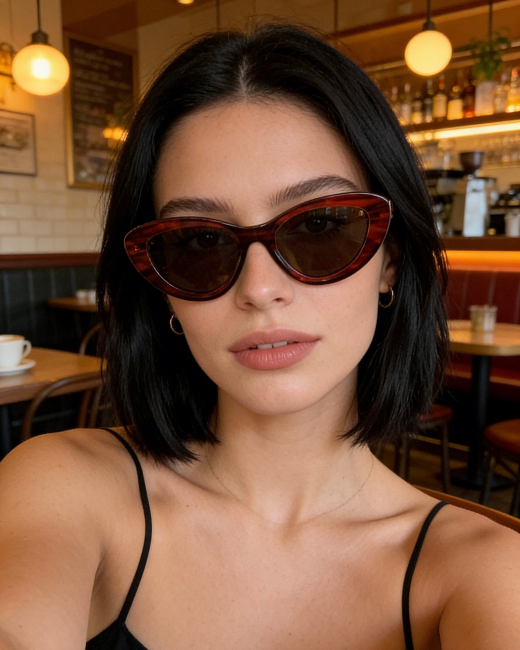 Bold black cat-eye sunglasses with thick frames, polarized lenses with UV protection, retro aesthetic eyewear for women. Brown wood grain pattern cat-eye sunglasses with tea-tinted polarized lenses and UV protection, vintage organic style eyewear.